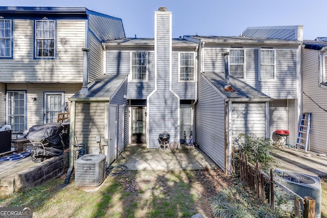 back of property featuring cooling unit, a patio area, and a chimney