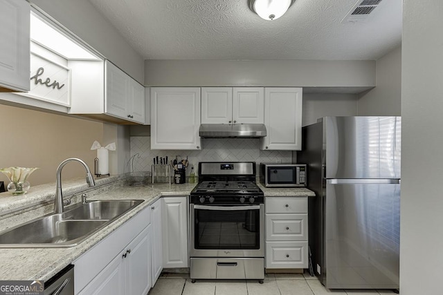 kitchen featuring white cabinets, under cabinet range hood, appliances with stainless steel finishes, and light countertops