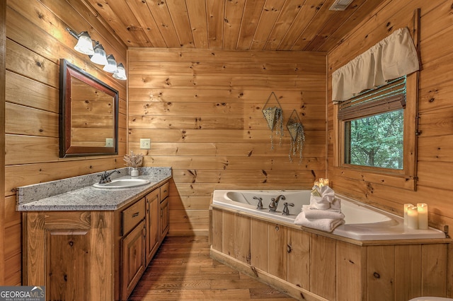 full bathroom featuring a garden tub, wood ceiling, wood walls, vanity, and wood finished floors