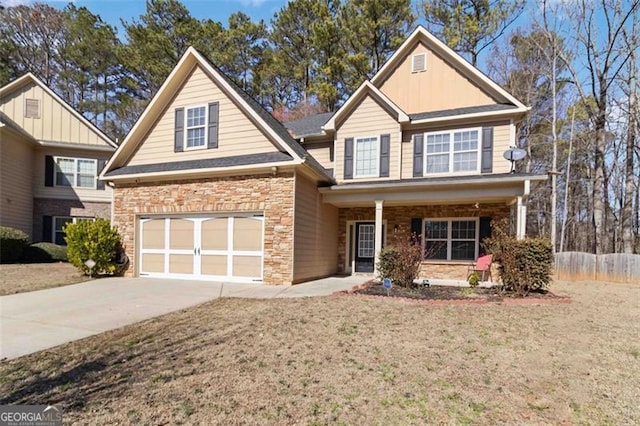 traditional home with a front yard, stone siding, and driveway