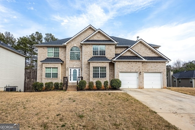 view of front facade with roof with shingles, central air condition unit, an attached garage, a front yard, and driveway