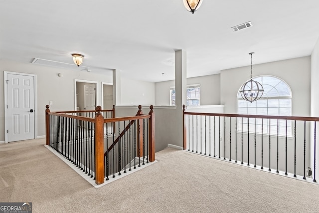 hallway featuring a wealth of natural light, carpet, an upstairs landing, and visible vents