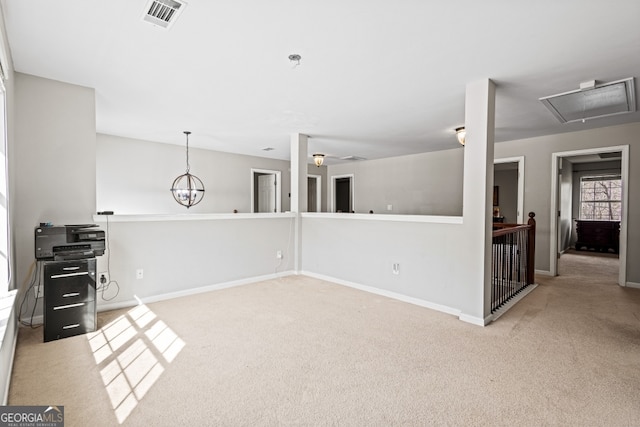 unfurnished living room featuring baseboards, carpet floors, visible vents, and attic access