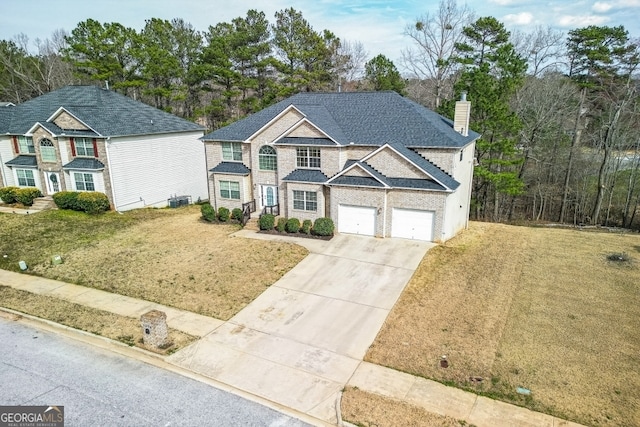 traditional-style home with concrete driveway, a front lawn, a chimney, and an attached garage