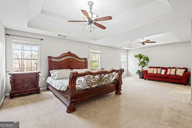 bedroom featuring a tray ceiling, carpet, a ceiling fan, and baseboards