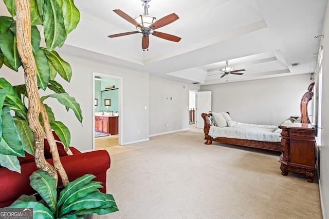 bedroom featuring ceiling fan, ensuite bathroom, light colored carpet, baseboards, and a raised ceiling