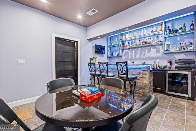 bar featuring wine cooler, a dry bar, recessed lighting, visible vents, and baseboards