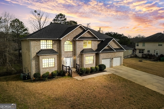 view of front of property with a lawn, concrete driveway, a chimney, central AC, and brick siding