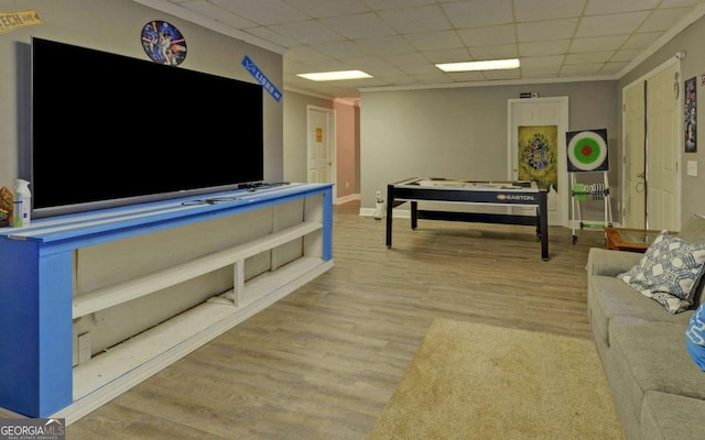 living area featuring light wood-type flooring, baseboards, and a drop ceiling