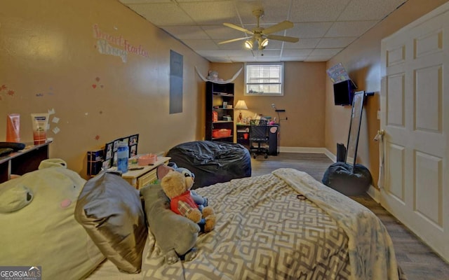 bedroom with a paneled ceiling, baseboards, and wood finished floors