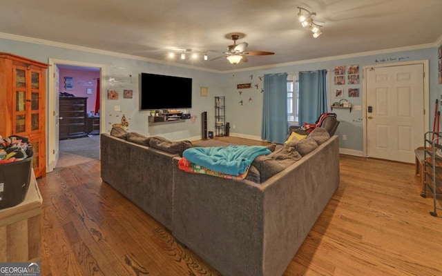 living room with baseboards, light wood-style flooring, ornamental molding, and a ceiling fan