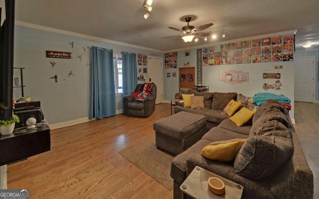 living room featuring ceiling fan, baseboards, wood finished floors, and crown molding