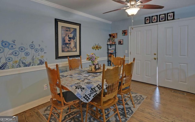 dining space with crown molding, visible vents, ceiling fan, wood finished floors, and baseboards