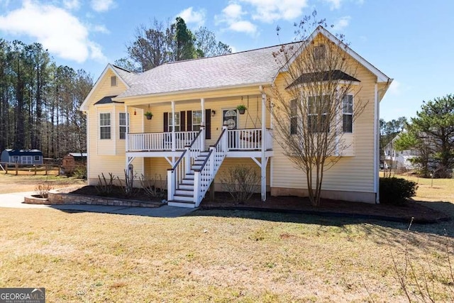 view of front of house featuring covered porch, a front lawn, and stairs