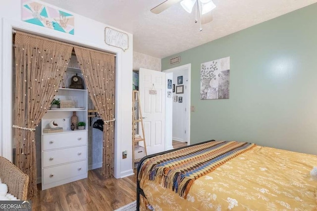 bedroom with a textured ceiling, wood finished floors, and a ceiling fan