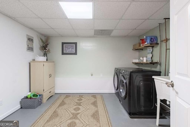 washroom featuring baseboards and separate washer and dryer