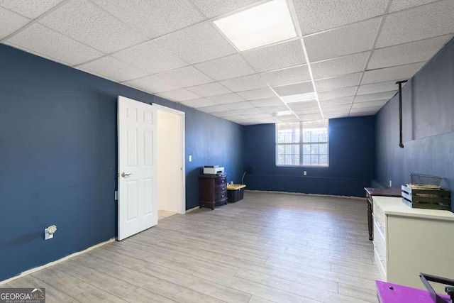 unfurnished office featuring a paneled ceiling and wood finished floors