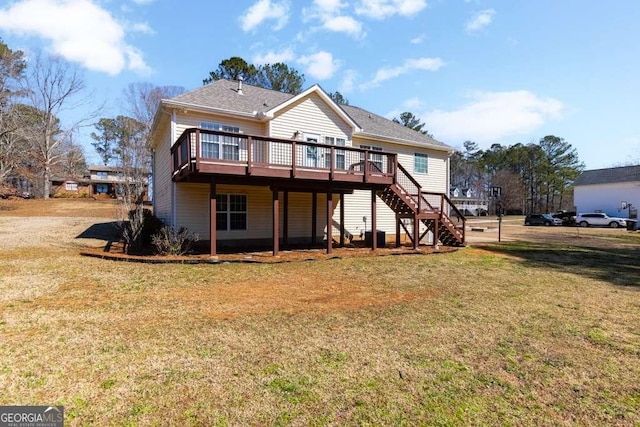 rear view of house featuring stairs, a deck, and a lawn