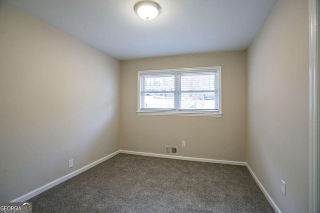 carpeted spare room with visible vents and baseboards