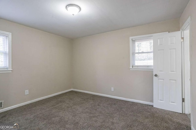 carpeted empty room with baseboards