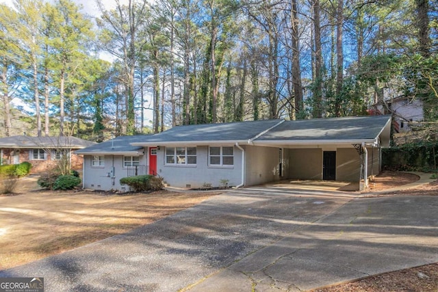 single story home with concrete driveway, an attached carport, and crawl space