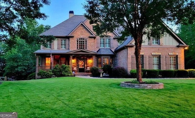 craftsman inspired home featuring a front lawn, a porch, and a chimney