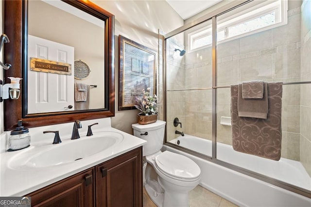 bathroom featuring enclosed tub / shower combo, toilet, tile patterned floors, and vanity