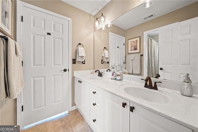 full bathroom featuring tile patterned flooring, visible vents, double vanity, and a sink