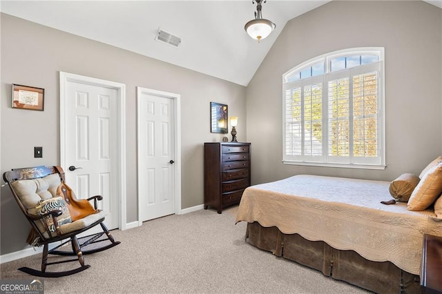 carpeted bedroom with visible vents, baseboards, and vaulted ceiling