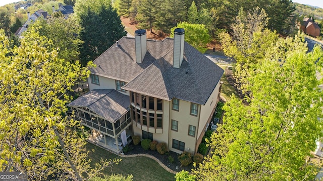 rear view of house with a chimney, fence, and a sunroom
