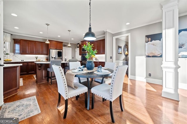 dining room featuring recessed lighting, crown molding, ornate columns, and wood finished floors