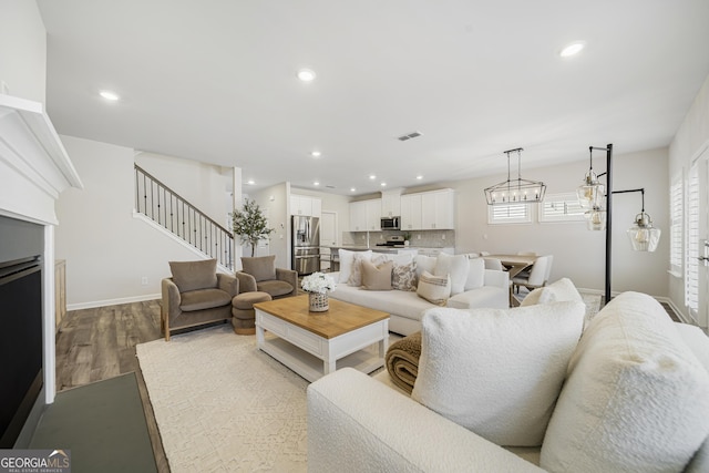 living room featuring stairway, recessed lighting, and wood finished floors