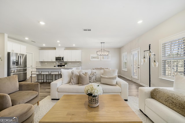 living room with recessed lighting, visible vents, and light wood-style floors