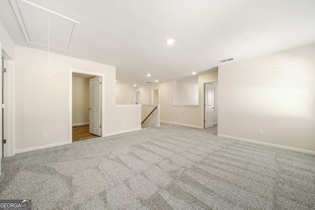 unfurnished living room with baseboards, visible vents, attic access, recessed lighting, and carpet flooring