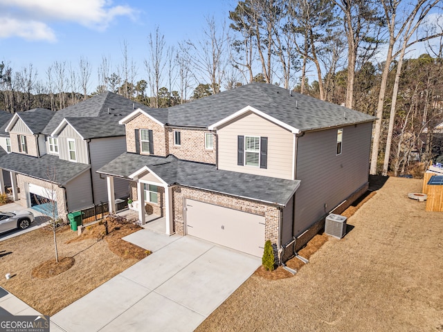 traditional home with concrete driveway, central air condition unit, brick siding, and a shingled roof