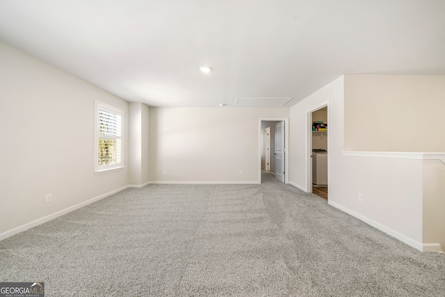 carpeted empty room with washer / dryer and baseboards