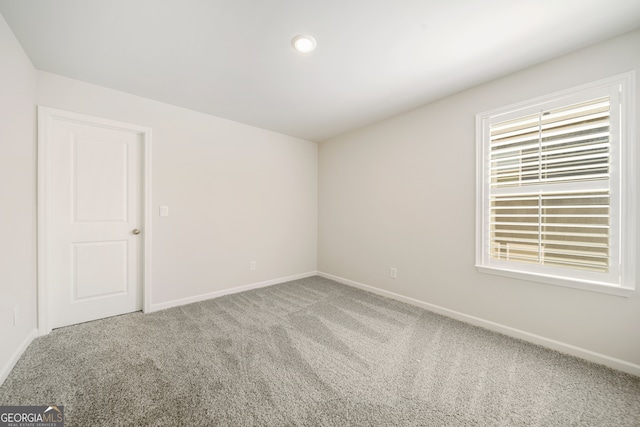 unfurnished room with a healthy amount of sunlight, baseboards, and carpet floors