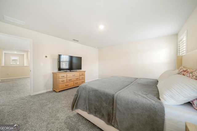 bedroom with visible vents, light colored carpet, and baseboards