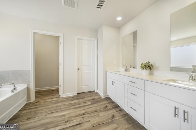 full bath featuring wood finished floors, visible vents, and a sink