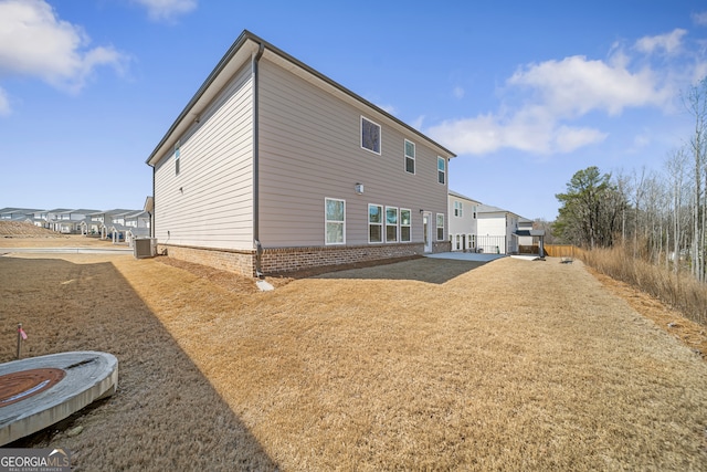 back of house with cooling unit, a patio, and brick siding