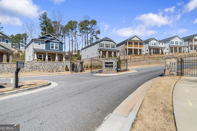 view of street featuring a gated entry, a residential view, curbs, sidewalks, and a gate