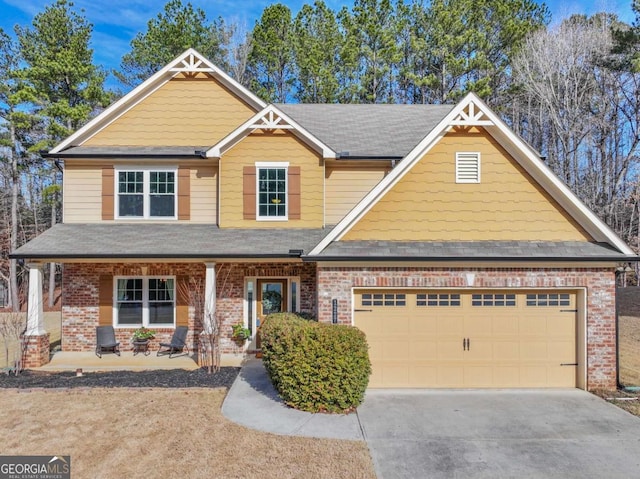 craftsman-style house featuring a garage, covered porch, concrete driveway, and brick siding