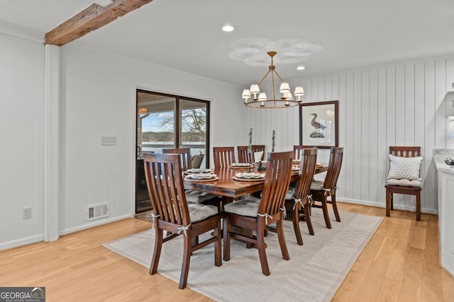 dining space featuring visible vents, baseboards, light wood-type flooring, beamed ceiling, and an inviting chandelier