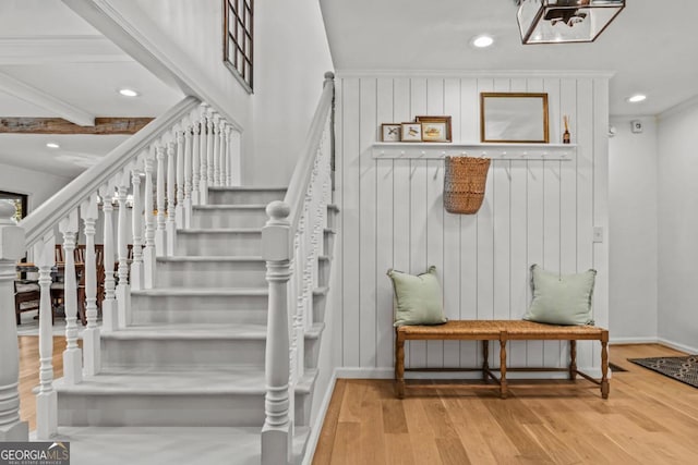 staircase featuring crown molding, baseboards, wood finished floors, and recessed lighting