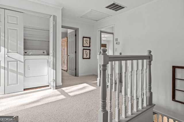 corridor with visible vents, attic access, ornamental molding, an upstairs landing, and washer / dryer