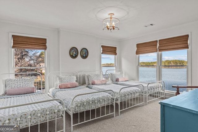 bedroom with ornamental molding, a water view, visible vents, and a notable chandelier