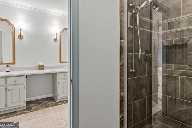 full bath featuring baseboards, ornamental molding, a tile shower, and vanity