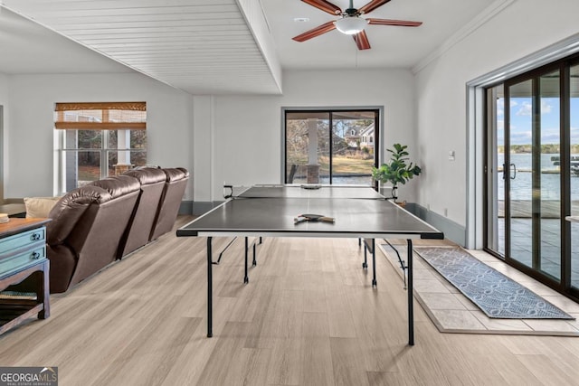 recreation room with light wood-type flooring, a wealth of natural light, and a water view