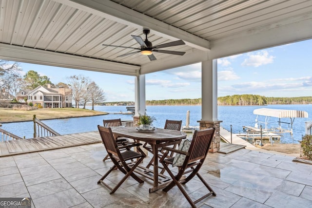 view of patio / terrace with a water view, outdoor dining area, and a ceiling fan