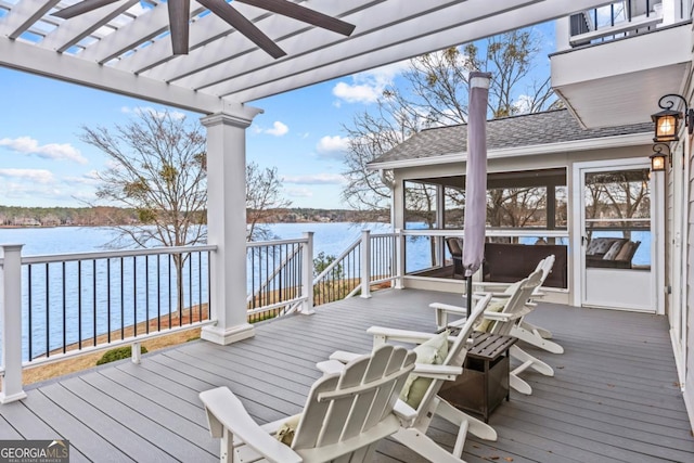 wooden deck with a water view, a sunroom, a ceiling fan, and a pergola